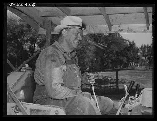 Wheat farmer on caterpillar tractor used to draw combine. Whitman County, Washington
