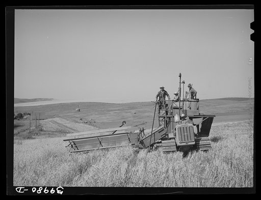 Caterpillar-drawn combine working in the wheat fields of Whitman County, Washington