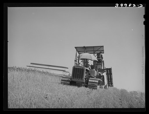 Caterpillar-drawn combine working in the wheat fields of Whitman County, Washington