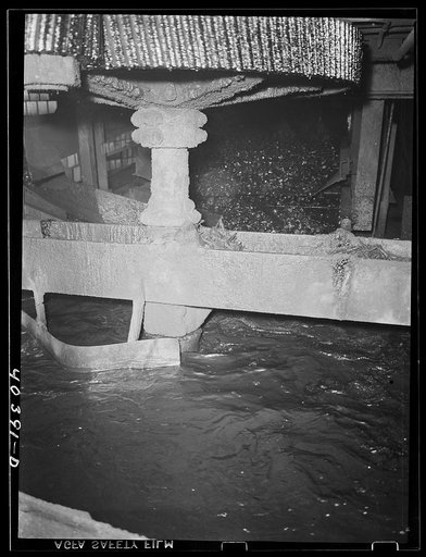 Gilberton, Pennsylvania. A Chance coal separator in operation in the Saint Nicholas breaker. The cone vat, filled with sand and water and kept in solution by agitation, causes the coal to float above the rock, allowing the rock to be taken from the bottom of the cone. Bits of timber and other debris
