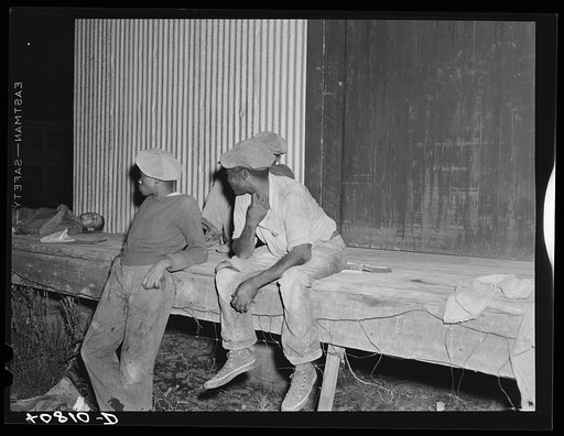 Migratory agricultural workers waiting to go on night shift at the grading station at Camden, North Carolina