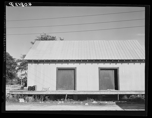 Warehouse that provides housing for a number of migratory agricultural workers. On the left is the baggage of some of the new arrivals. Camden, North Carolina