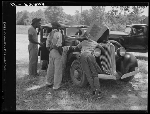 Migrants repairing motor before leaving Old Trap, North Carolina, for New Jersey
