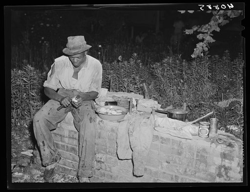 Migratory worker at Belcross, North Carolina, grading station preparing supper to be cooked over an open fire