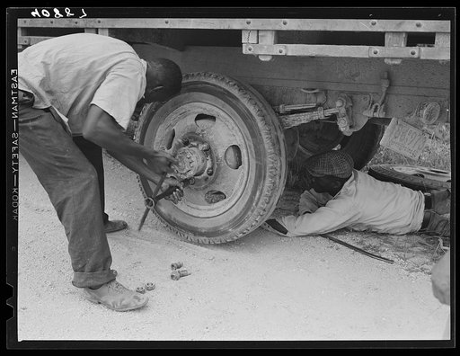 Repairing tire of a truck carrying thirty-five migratory agricultural workers from North Carolina to pick beans near Easton, Maryland