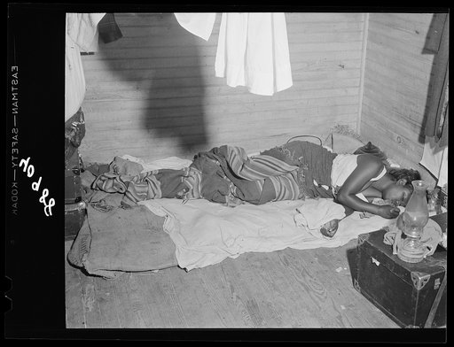 Belcross (vicinity), North Carolina. A girl sleeping in an old farmhouse which she shares with thirty-five other people