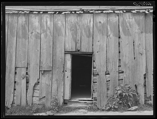 An old log cabin occupied by the family of FSA (Farm Security Administration) client George W. Green. A new house is being built directly behind this one. Saint Inigoes, Maryland