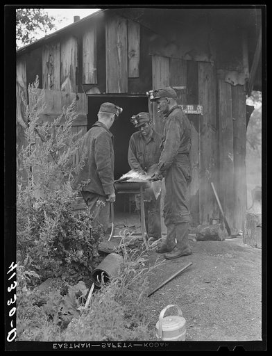 Miners at Dougherty's mine, near Falls Creek, Pennsylvania, sharpening their axes at the end of a day's work