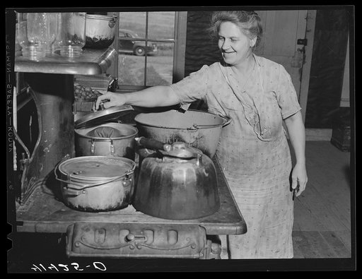 Mrs. Ben Harris preparing the evening meal. The Harrises come from Luzerne County, Pennsylvania. They have goats and sell goats milk. Live in submarginal farm area of Rumsey Hill, near Erin, New York