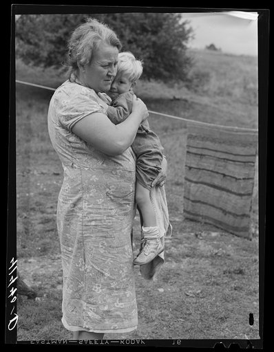 Farm woman holding one of her children in submarginal farm area of Rumsey Hill, near Erin, New York