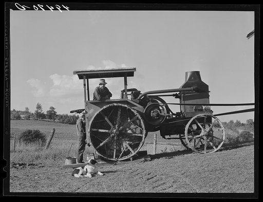 Hired man working tractor engine used for threshing on farm of Alfred Shaffner, a farmer in the submarginal area of Sugar Hill, near Townsend, Connecticut