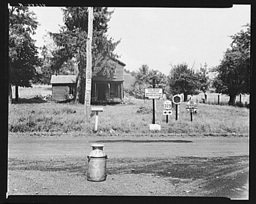 Road intersection with milk can waiting to be picked up by delivery truck. Townsend, New York