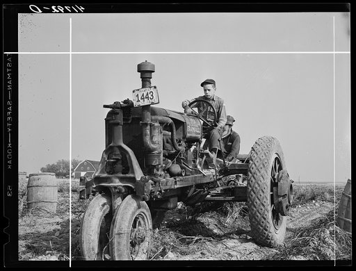 Tractor-drawn potato digger in a field near Caribou, Maine