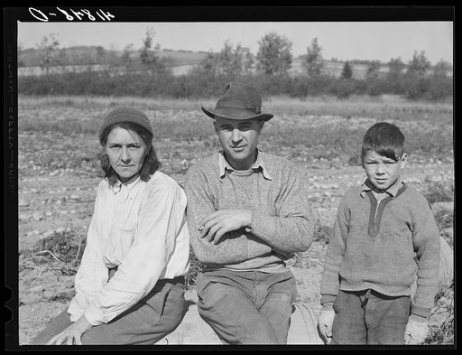 Very often entire families will become part of a large crew of potato pickers. French-Canadian mother, father and son during lunch hour in a field three miles out of Caribou, Maine