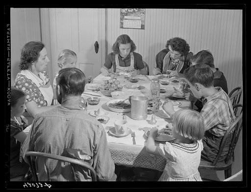 Untitled photo, possibly related to: Dinner hour at the home of Mr. J.H. Dube, French-Canadian potato farmer, after he and the boys had finished a day's work in their potato field in Wallagrass, Maine