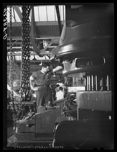 A special drill press cuts a great number of holes simultaneously in casings for engines at the Pratt and Whitney Aircraft Corporation. East Hartford, Connecticut