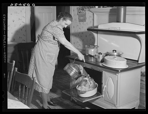 Mrs. T. M. Crouch, of Ledyard. Connecticut pouring some water over her twenty-pound turkey on Thanksgiving Day