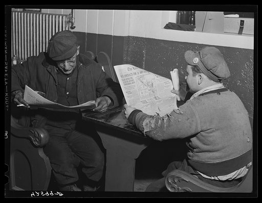 Shipyard workers reading Bath paper in a bar near shipyard. Bath, Maine
