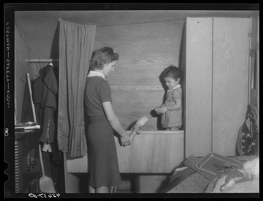 Mrs. Robert R. Reynolds and her little girl. Mr. Reynolds works at the Bath Iron Works. They came to Bath about three months ago from Bethel, Maine and have been living in the trailer since they came. Get water, etc., from house nearby