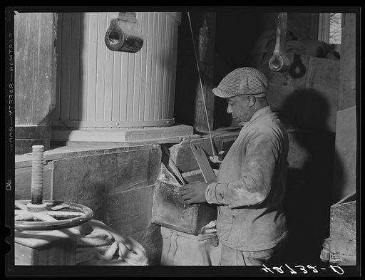 Filling a sack with freshly-ground flour in Kenyon's johnnycake flour mill in Usquepaugh, Rhode Island