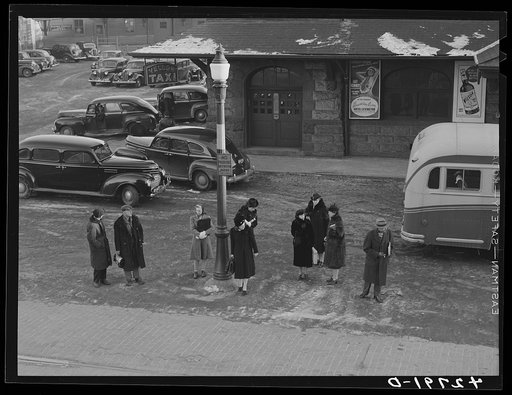 Untitled photo, possibly related to: Commuters who have just gotten off the train waiting for the bus to go home. Lowell, Massachusetts