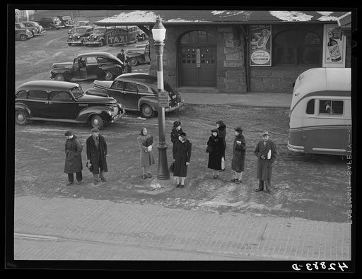 Untitled photo, possibly related to: Commuters who have just gotten off the train waiting for the bus to go home. Lowell, Massachusetts