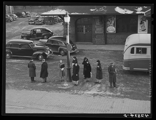Commuters who have just gotten off the train waiting for the bus to go home. Lowell, Massachusetts