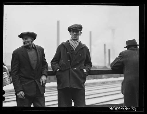 Steelworkers of the Jones and Laughlin Steel Corporation in Aliquippa Pennsylvania waiting for a bus to go home at the end of the afternoon shift