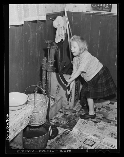 Daughter of a worker at the Pittsburgh Crucible Steel Corporation of Midland, Pennsylvania. Her father is at present in bed as a result of a leg injury at the mill. There are seven children and they help out by selling magazines from door to door. The pump is the only source of water