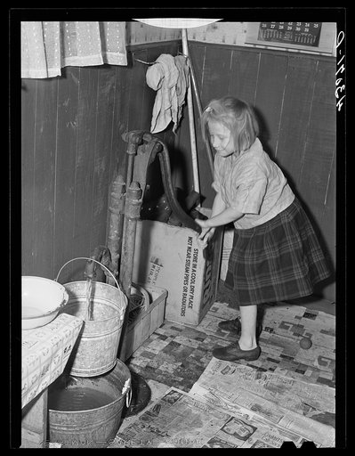 Untitled photo, possibly related to: Daughter of a worker at the Pittsburgh Crucible Steel Corporation of Midland, Pennsylvania. Her father is at present in bed as a result of a leg injury at the mill. There are seven children and they help out by selling magazines from door to door. The pump is the