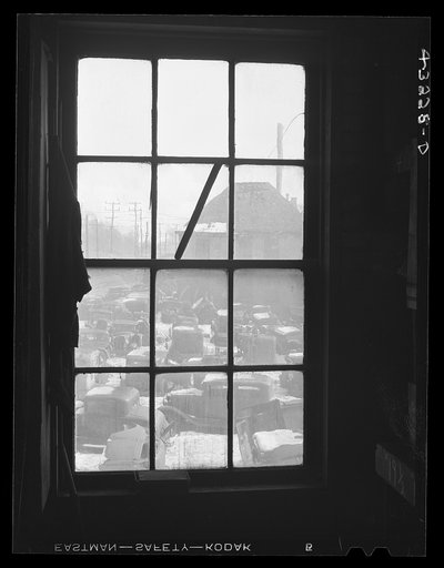 Untitled photo, possibly related to: Auto graveyard seen thru a window of the abandoned Olive Stove Works, Rochester, Pennsylvania