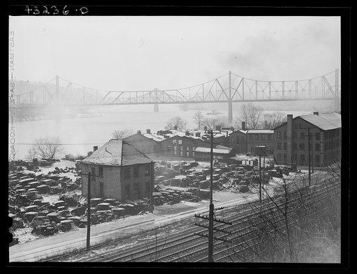 Untitled photo, possibly related to: Auto graveyard next to abandoned stove works (right) in Rochester, Pennsylvania