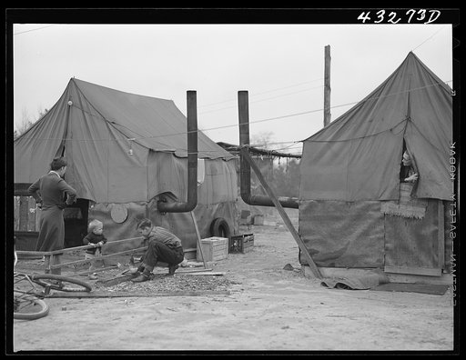 Tent of migratory workers employed at Fort Bragg, North Carolina. These tents were part of a small settlement at Manchester, North Carolina (about twelve miles from Fayetteville). They were paying a dollar a week for tent space-- this included water and light. One spigot at the general store furnish