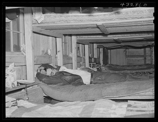 Man who works at Fort Bragg, North Carolina sleeping in a bunk house recently built to house thirty or forty men. There were only a few men left, most of them having been laid off had left. A few miles out of Fayetteville, North Carolina