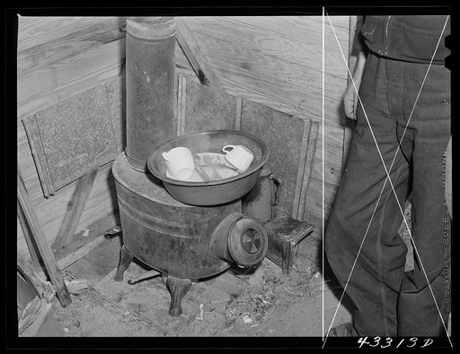 Washing dishes in a shack occupied by workers from Fort Bragg, North Carolina. Near Fayetteville