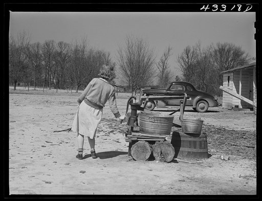 Untitled photo, possibly related to: Woman fetching water. She lives with her family in lower part of the tobacco barn. Husband works at Fort Bragg. Near Fayetteville, North Carolina