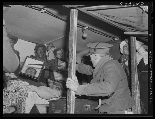 Inside the travelling sideshow "crime museum". The owner, an old war veteran, is pointing out the exhibits. Near Fort Bragg, North Carolina