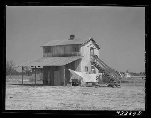 Untitled photo, possibly related to: Tobacco barn converted into living quarters for families of workers from Fort Bragg. Near Fayetteville, North Carolina