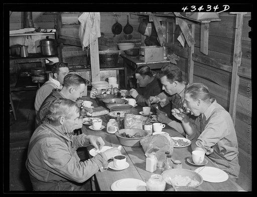 Migratory workers from Fort Bragg eating supper at a trailer settlement in Manchester, North Carolina