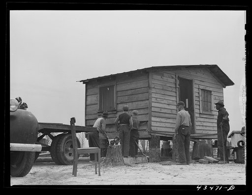 Moving a small outbuilding from the Santee-Cooper Basin by means of a trailer truck. Near Bonneau, South Carolina