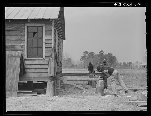 Untitled photo, possibly related to: Building a porch for a house that had been carried out of the Santee-Cooper basin by a Negro family. Near Bonneau, South Carolina region