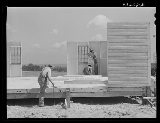 Building porch on prefabricated houses to be used to house some of the farmers that had to move out of Camp Croft area. Pacolet, South Carolina