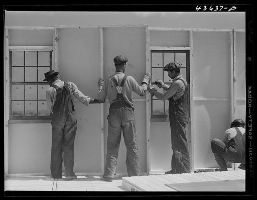 Bolting a wall together in one of the prefabricated houses built by FSA (Farm Security Administration) for farmers moved out of the Camp Croft area.  Pacolet, South Carolina region