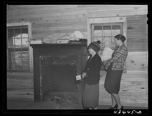 Mrs. Harvey and a neighbor watching her belongings being moved out of her house in the Camp Croft area near Whitestone, South Carolina