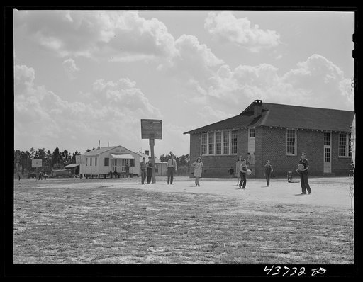 Untitled photo, possibly related to: The white schoolhouse in the background was erected by Hazlehurst Farms Inc. to accommodate the increased enrollment as a result of families moving into prefabricated houses