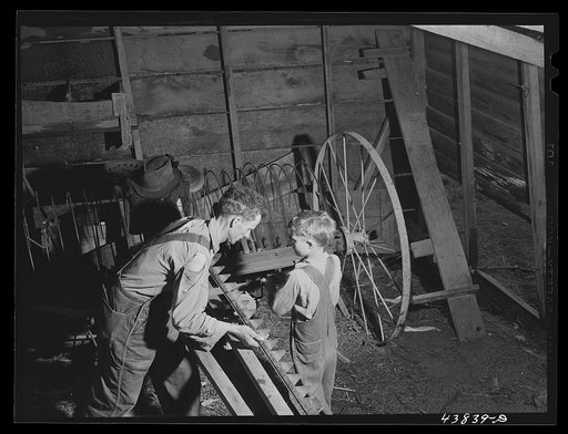 On a rainy day Mr. Lemuel Smith, FSA (Farm Security Administration) borrower, sharpens some of his co-operatively owned farm implements. Carroll County, Georgia (See general caption)