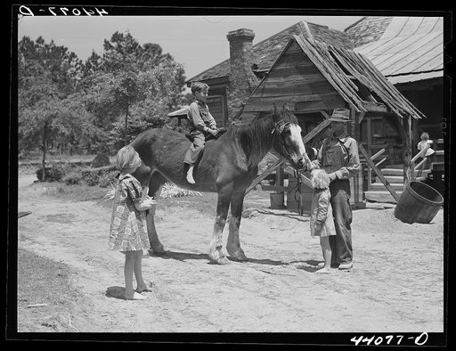 Colie Smith gets a ride on one of two horses owned by the Smith family. Carroll County, Georgia