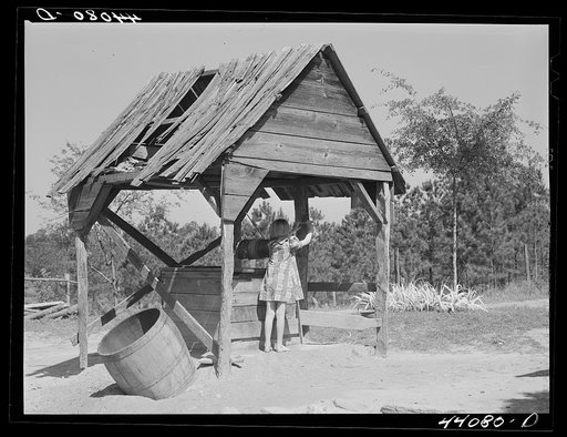 Iola Smith, drawing water from the well for which Mr. Smith, FSA (Farm Security Administration) borrower, built a cement foundation. Carroll County, Georgia