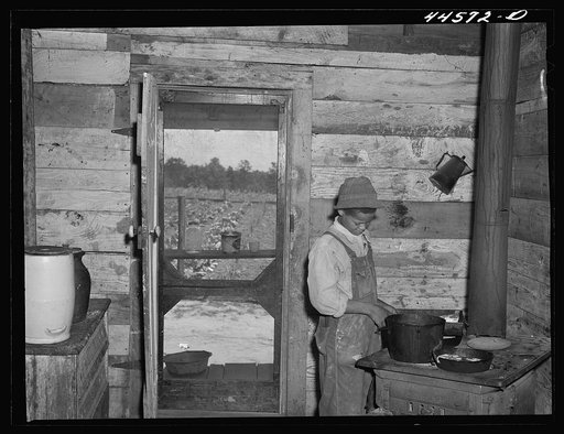 One of the children of R. L. Smith, preparing dinner for the rest of the family. FSA (Farm Security Administration) borrower. Greene County, Georgia
