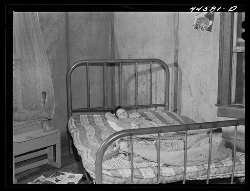 Young boy in bed with measles in the home of a FSA (Farm Security Administration) borrower. Greene County, Georgia